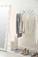 Fototapeta na wymiar Rack with clean female clothes in dressing room