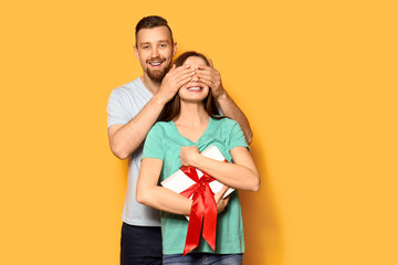 Young man greeting his girlfriend on color background