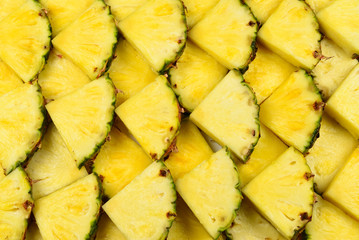 Pineapple juicy yellow slices background. Top view.