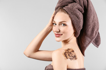 Fototapeta premium Young woman with body scrub on her body against grey background