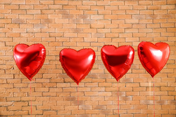 Heart shaped air balloons on brick background
