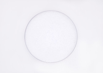 White sea salt crystals in round cap on a white  background
