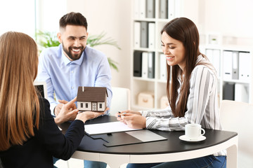 Young couple in office of real estate agent
