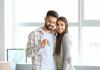 Young couple with keys in their new house