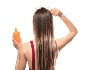Fototapeta premium Beautiful young woman with bottle of sun protection cream on white background