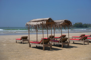 Beautiful Sri Lankan view of the Indian Ocean with sun loungers on the beach. Summer holidays in Asia. Stock photos