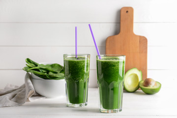 Glasses of fresh smoothie on white table