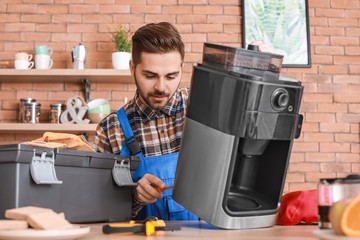 Man repairing coffee machine in kitchen