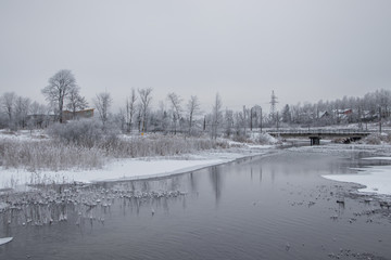 Winter landscape on the river. Snow picture. Snow and river. Cloudy snow day.