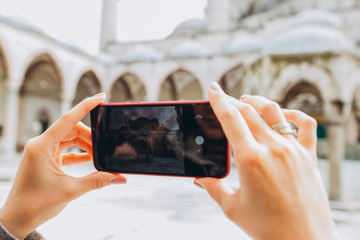 Popular tourist destination in Istanbul, Turkey. A woman makes a photo from the phone camera in Istanbul. Blue sword, or the Sultanahmet mosque