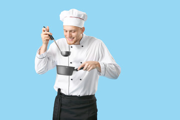 Handsome male chef with sauce on color background