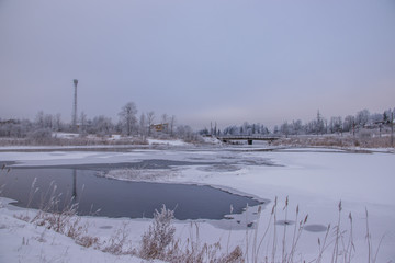 Winter landscape on the river. Snow picture. Snow and river. Cloudy snow day.