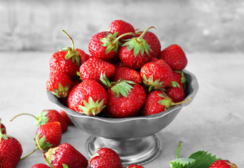 Colander with ripe red strawberry on table