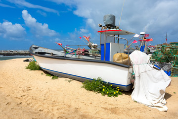 White fishing boat on the sandy shore