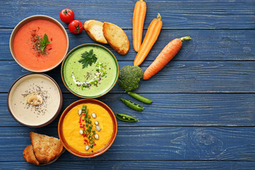 Bowls of tasty cream soups on table