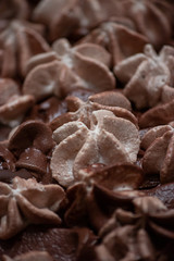 layers of varigated frosting swirled on top of a thin layer coffee flavored cake on a platter set on a table in a kitchen