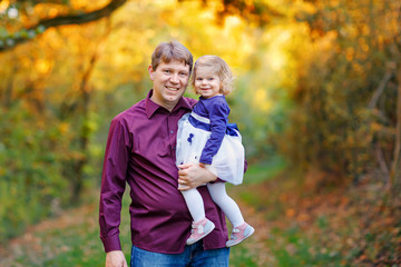 Happy young father having fun cute toddler daughter, family portrait together. man with beautiful baby girl in nature and forest. Dad with little child outdoors, hugging. Love, bonding.