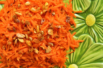 Carrot salad with peanuts on a green background