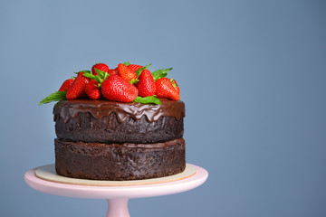 Tasty chocolate cake with strawberry on color background