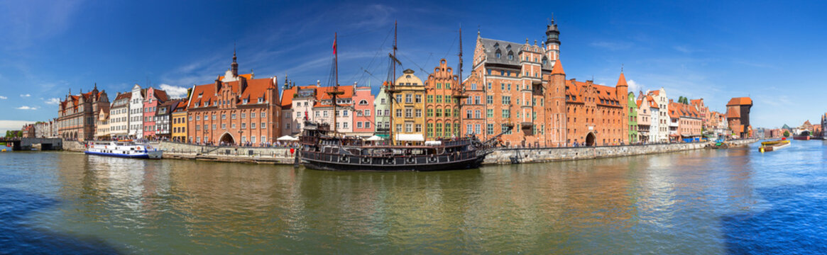 Panorama of the old town in Gdansk with historical port crane reflected in Motlawa river, Poland