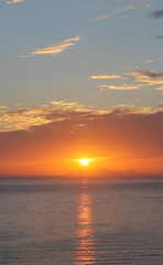 Obraz premium Beautiful summer sunset or sunrise by the sea. Red and orange spectacular cloudy sunset vertical background.