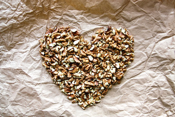 a heart of walnuts on a brown paper background, love for a healthy food/diet. Benefit concept