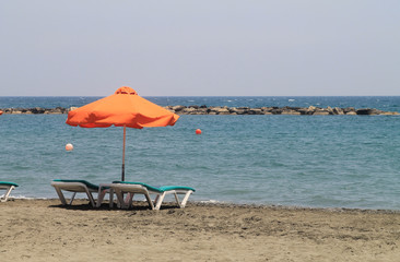 Umbrella and two sun beds on a beach