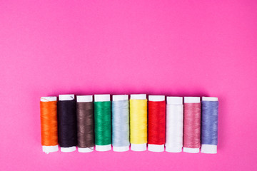 multicolored threads on a pink