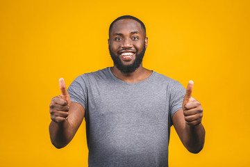 Portrait of cheerful, positive, handsome man with black skin, beaming smile in casual showing thumb...