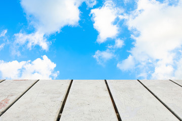Old Wooden table with blue sky white cloud background.