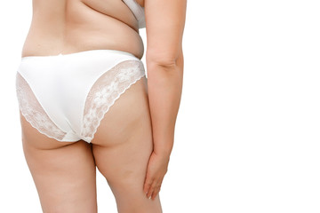 a woman with excess weight applying cream on the buttocks and legs