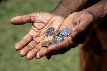 Coins in dark working hands. Beyond the poverty line in Asian countries. Subject soap bar.