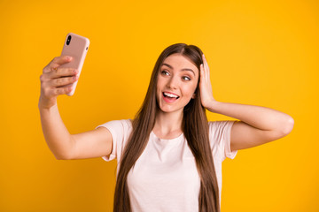 Close up photo beautiful amazing she her lady very long hairstyle hold hands arms telephone make take selfies speak tell skype friends wear casual pastel t-shirt isolated yellow bright background