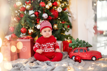 christmas baby boy near tree and gifts