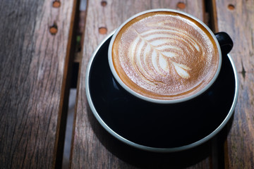 Latte art, coffee latte cup on a wood table.