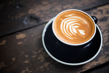 Latte art, coffee latte cup on a wood table.