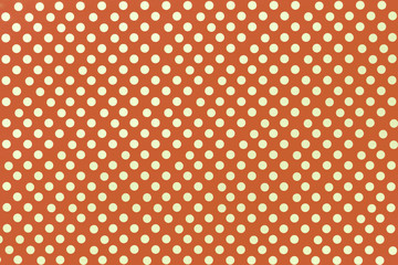Light orange background from wrapping paper with a pattern of golden polka dot closeup.