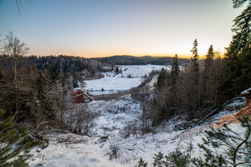 winter surise over countryside fields and forest in cold