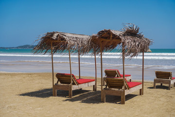 Plakat Beautiful Sri Lankan view of the Indian Ocean with sun loungers on the beach. Summer holidays in Asia. Stock photos
