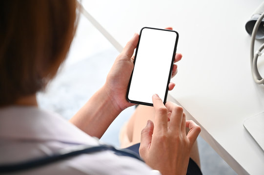 Top view  doctor using smartphone with empty screen display.
