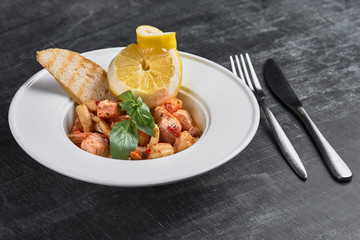 pasta with shrimp and fish on a dark background. Restaurant, food menu, recipe, cafe concept.