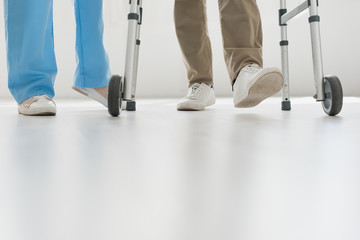 Cropped view of doctor and senior man walking on floor with copy space
