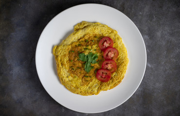 Omelette with tomatoes slide, coriander and scallion.