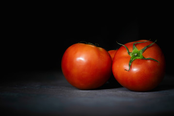 Tomatoes over dark background