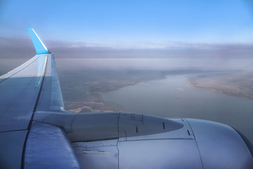 Fototapeta na wymiar View from the airplane window on the river below. Tourist route to warm countries. The theme of the travel agency. Stock photo