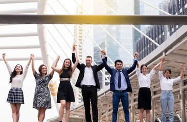 Fototapeta premium Mergers and acquisition,Successful group of business diversity people,Team success achievement hand raised up at outdoor