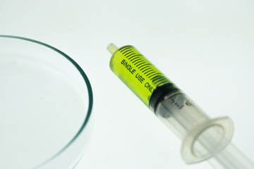 Erlenmeyer flask and a syringe lying on a white background.