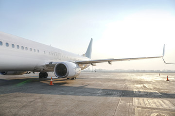 Passenger aircraft at the airport near the terminal. Unloading and loading baggage. Stock photo