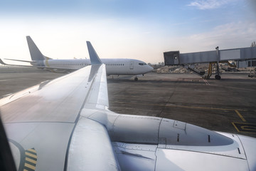 Fototapeta na wymiar Passenger aircraft at the airport near the terminal. Unloading and loading baggage. Stock photo