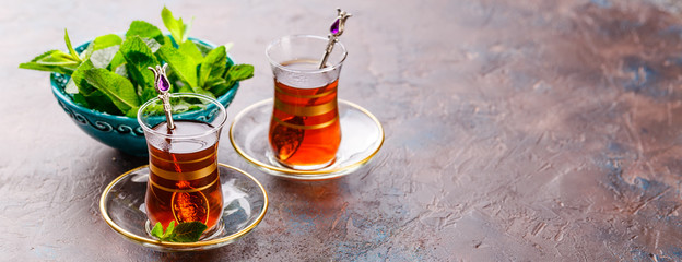 Traditional Turkish arabic dessert and a glass of tea with mint